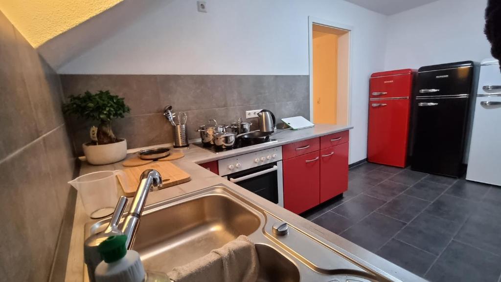 a kitchen with a sink and a red refrigerator at Pension-Maulburg in Maulburg