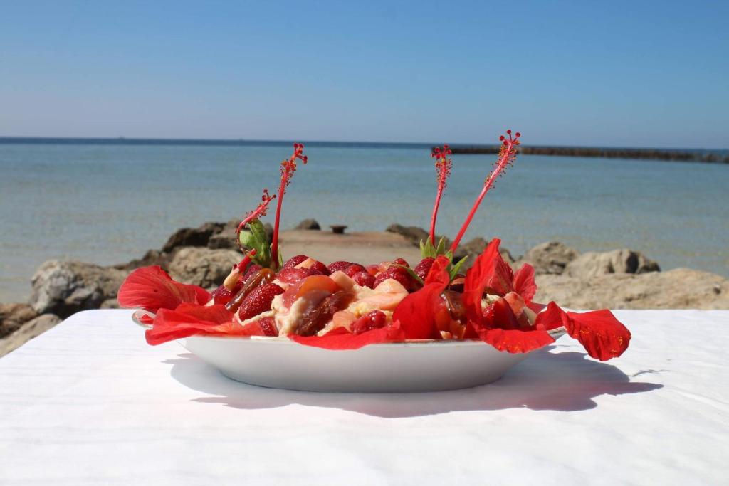 ein Teller mit Essen auf einem Tisch neben dem Strand in der Unterkunft Casa Mia in Ouled Kacem