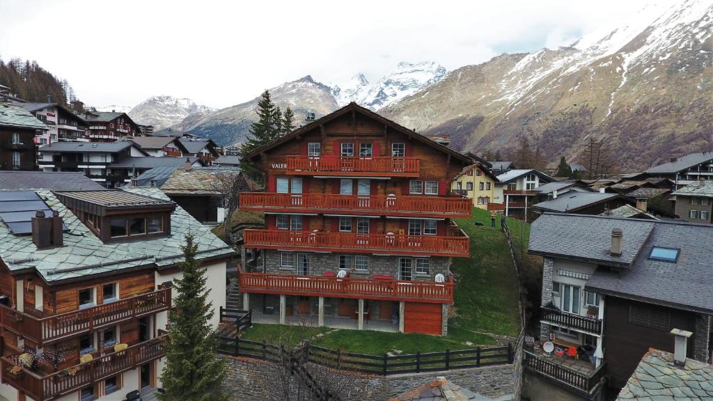 un grand bâtiment au milieu d'une ville avec des montagnes dans l'établissement Chalet Valeria, à Saas-Fee