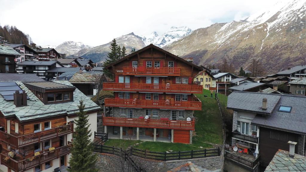 a large building in the middle of a town with mountains at Chalet Valeria in Saas-Fee