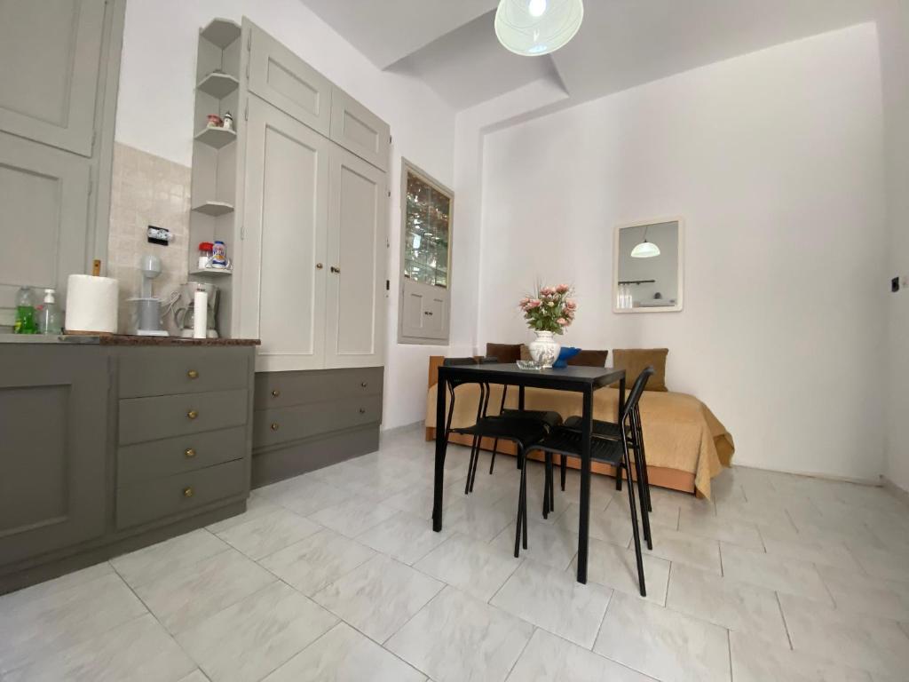 eine Küche mit einem Tisch und einem Bett in einem Zimmer in der Unterkunft Casa Plakes in Ermoupoli
