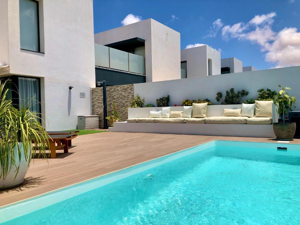 een zwembad voor een huis met een bank bij Villa Raffaella in Villaverde