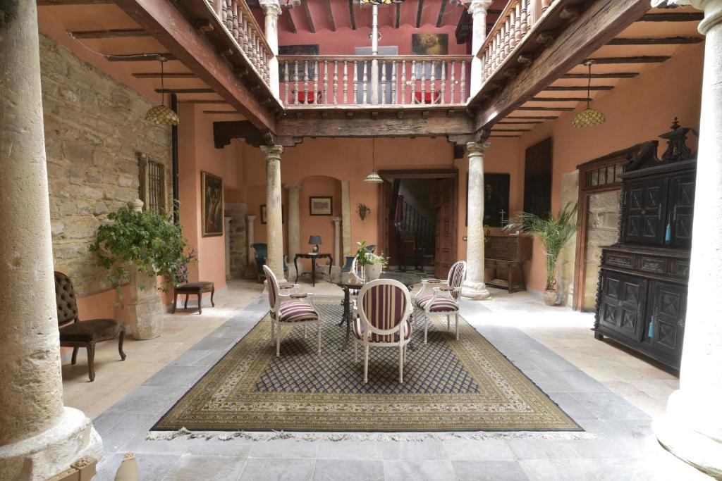 un patio avec une table et des chaises dans un bâtiment dans l'établissement Casa Palacio el Caballero de Malta, à Úbeda