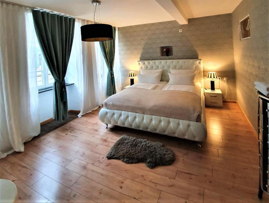 a bedroom with a large white bed and a wooden floor at Design Apartment BarcelonaNights in Freiburg im Breisgau