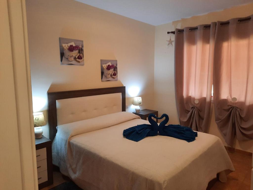 um quarto com uma cama com um roupão azul em Corralejo Happy em Corralejo