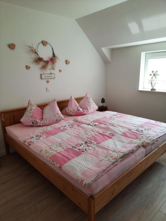 a bedroom with a large bed with pink sheets and pillows at Zum Landmann in Luhdorf