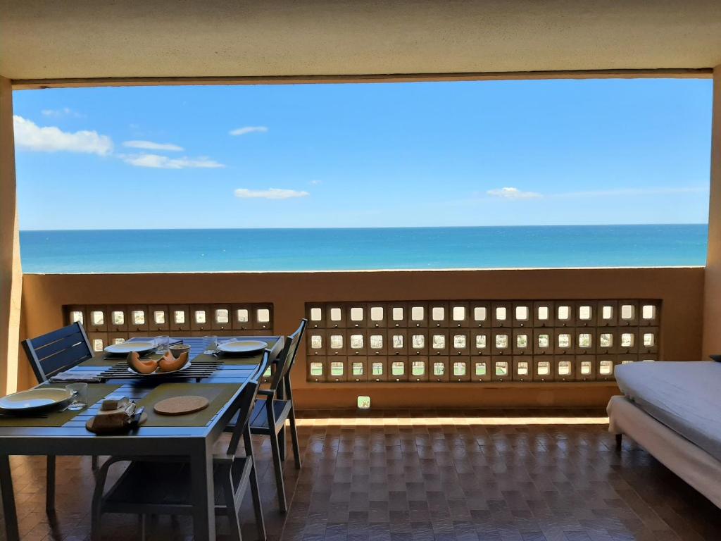 une pièce avec une table et une vue sur l'océan dans l'établissement Face à la mer, au Barcarès