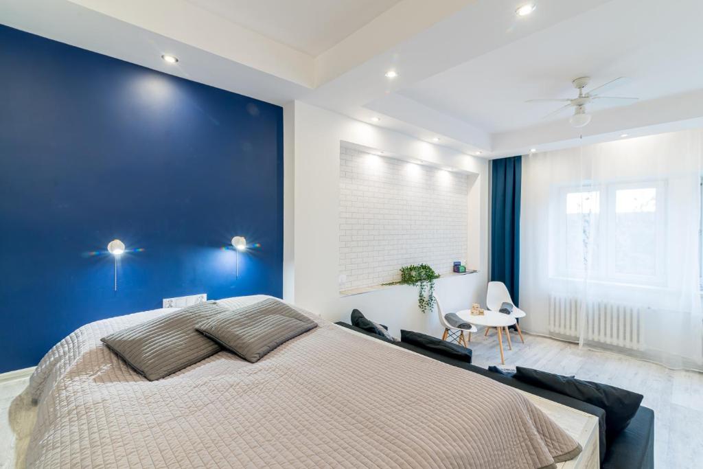 a bedroom with a large bed and a blue wall at Lux Apartment in white in Gdańsk
