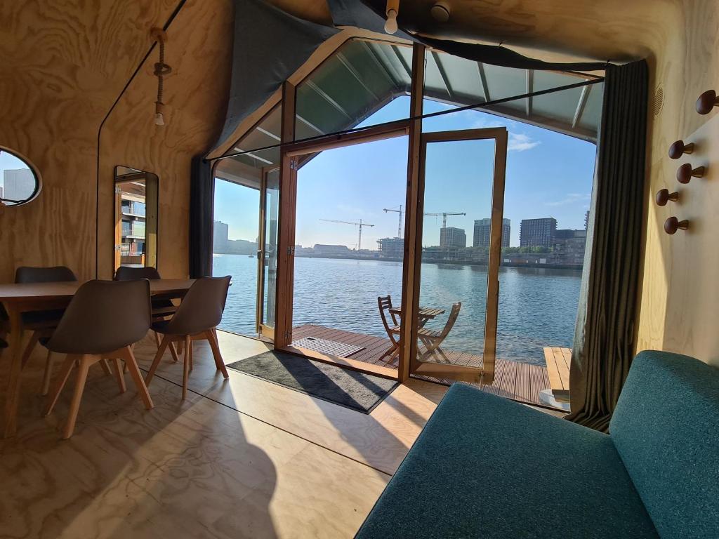 a dining room with a view of the water at Wikkelboat Nr1 at Floating Rotterdam Rijnhaven in Rotterdam