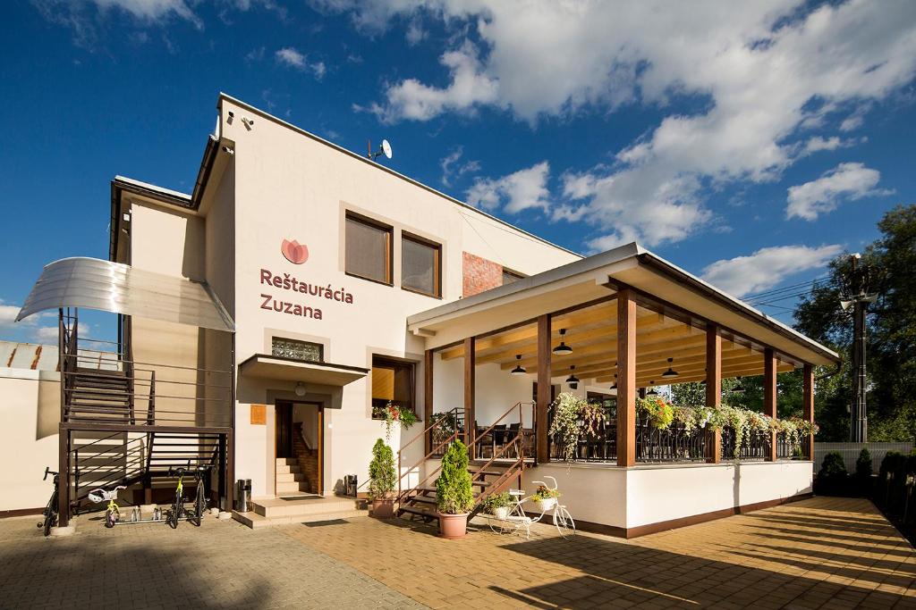 a white building with a patio in front of it at Ubytovanie Zuzana in Liptovská Teplá