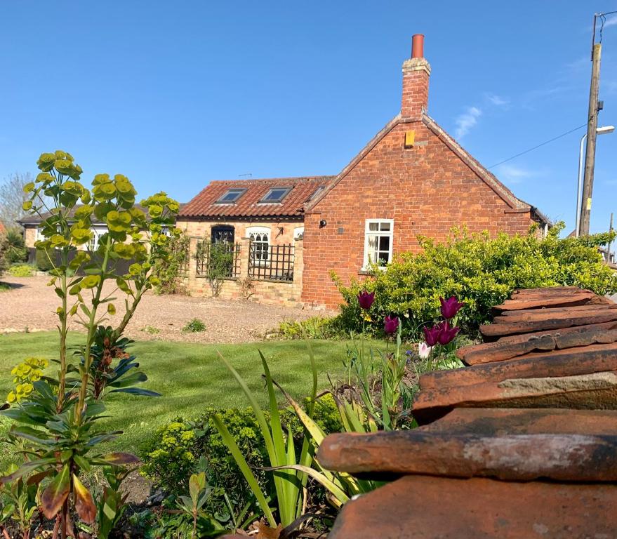 a brick house with a garden in front of it at The Old Stable in Sleaford