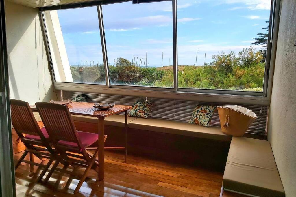 une table et deux chaises dans une pièce avec une fenêtre dans l'établissement Adorable studio cabine vue mer - 2/4 personnes, à Saint-Jean-de-Monts