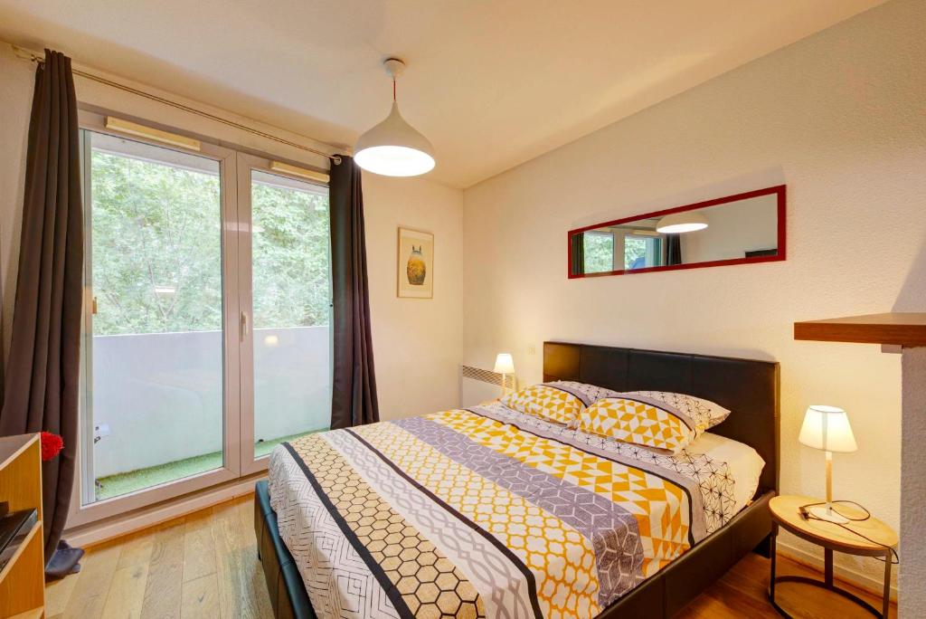 a bedroom with a bed and a large window at Le Brienne Toulouse Centre in Toulouse