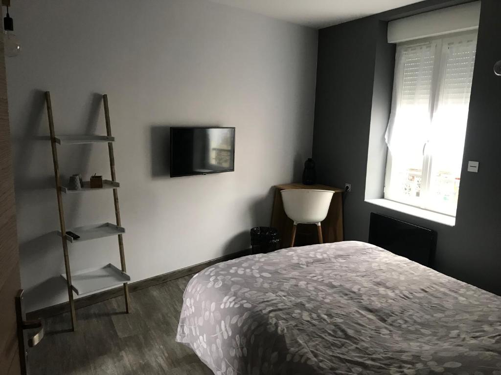 ein Schlafzimmer mit einem Bett und einem TV an der Wand in der Unterkunft Suite 1 Cosy in Cosne Cours sur Loire