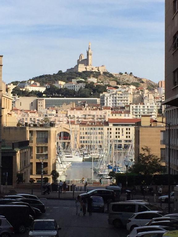 une ville avec des voitures garées dans un parking dans l'établissement Typique T2 Terrasse situé Quartier Panier Vieux Port, à Marseille