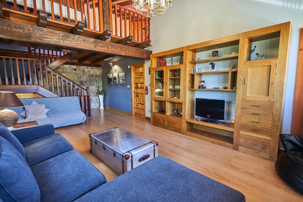 a living room with a blue couch and a tv at Garai Etxea, casa adosada en la montaña in Arrankudiaga