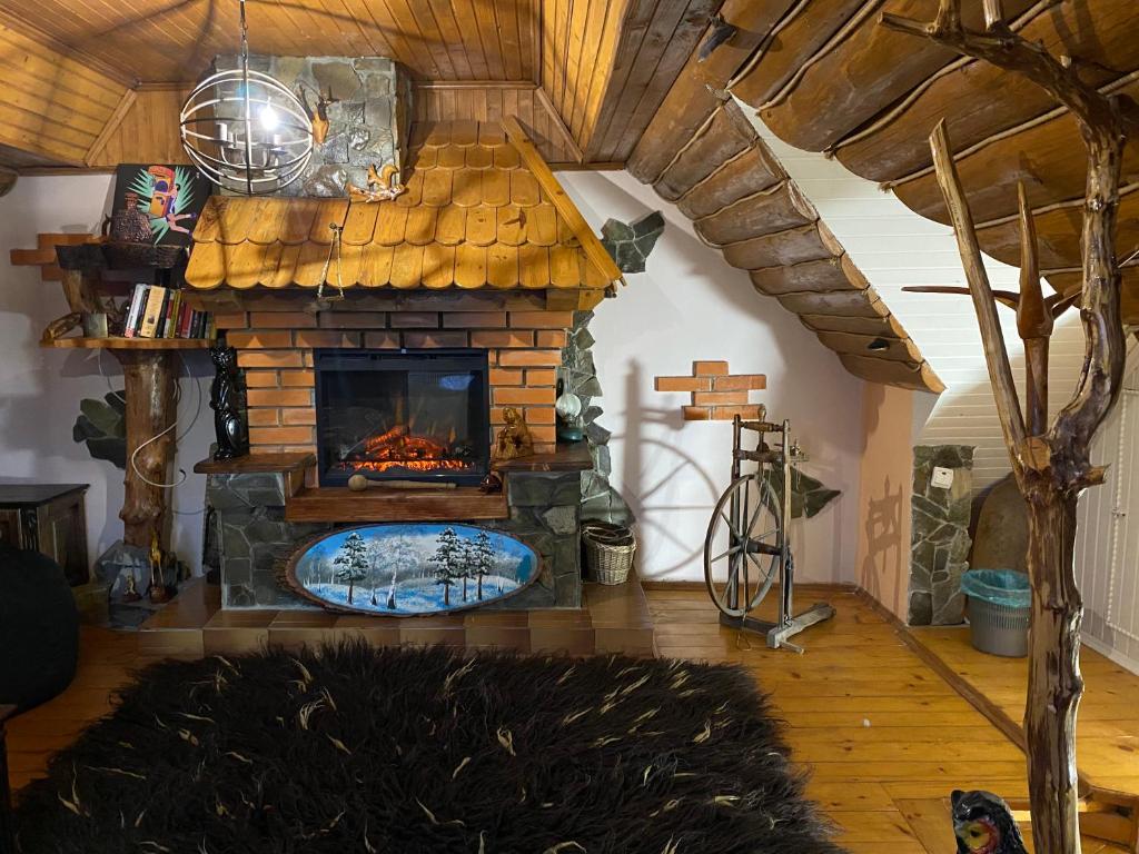 - un salon avec une cheminée en pierre dans une maison dans l'établissement VХаті, à Slavsko
