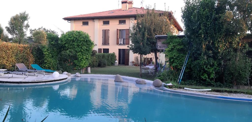 uma grande piscina em frente a uma casa em B&B Torricella em San Giorgio di Piano