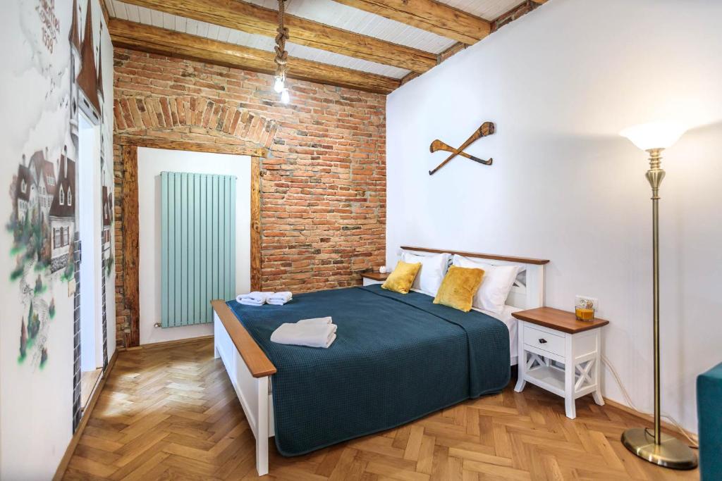 a bedroom with a bed and a brick wall at Saint John's 22 Brasov in Braşov
