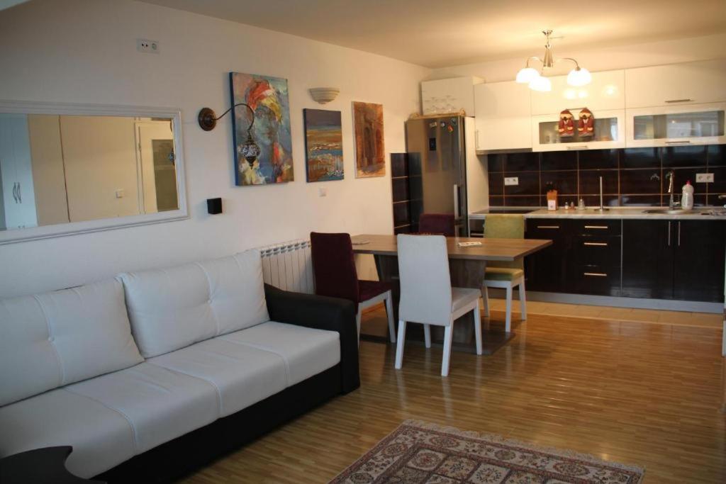 a living room with a couch and a table and a kitchen at Apartments Town Center in Sarajevo