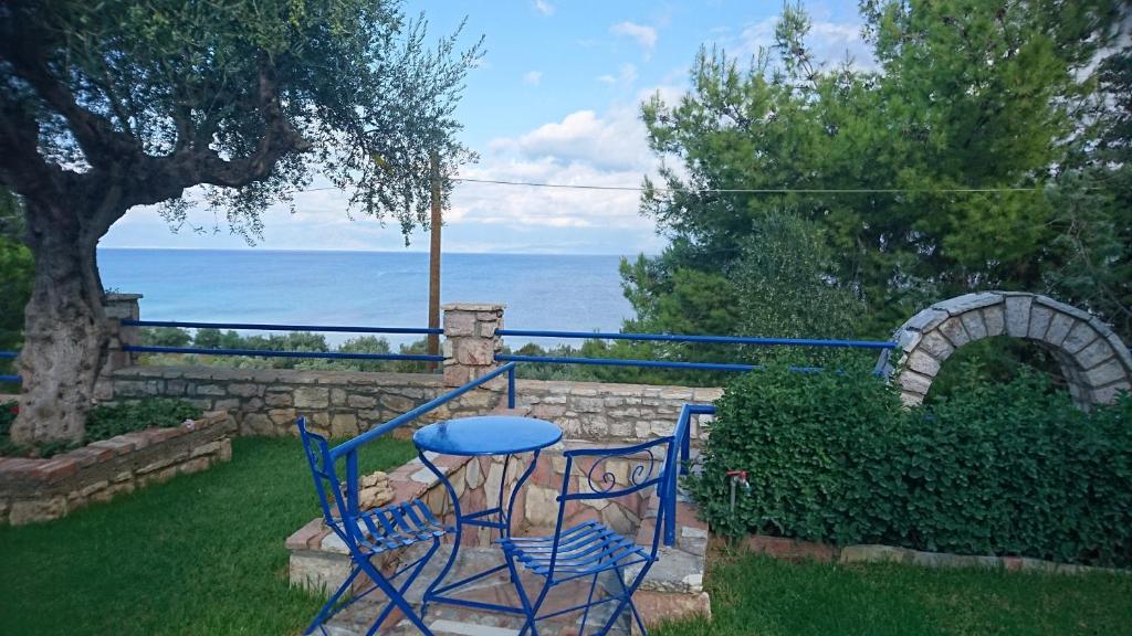 a blue table and chairs in a yard with the ocean at Villa Tasos Koutsoubos in Koroni