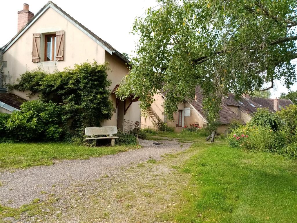 uma casa com um banco no quintal em Désert et Bocage em Saint-Aubin-le-Monial