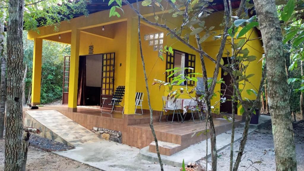 a yellow house with a table in front of it at Recanto Gira Cerrado in Cavalcante