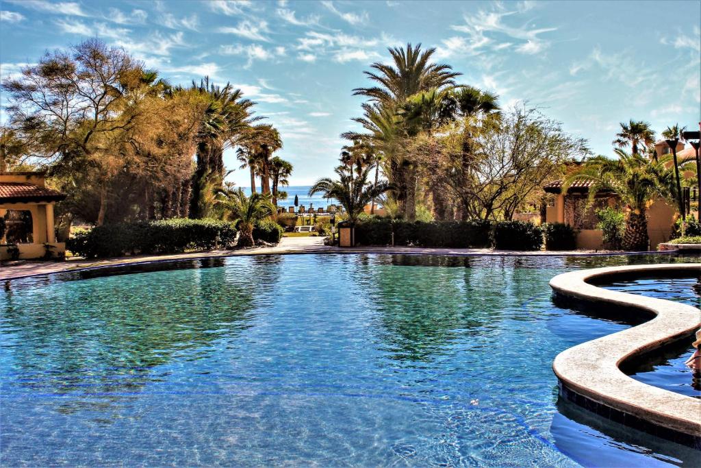 una piscina en un complejo con palmeras en Bella Sirena Luxury Condo 205-B en Puerto Peñasco