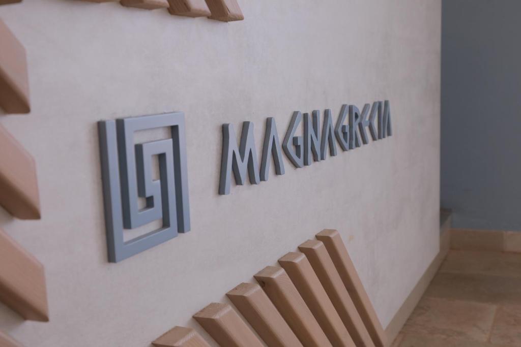 una scala in una stanza con cartelli sul muro di Hotel Magna Grecia a Leuca