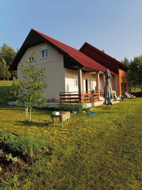a house with a tree in front of it at Apartman Bojovic in Žabljak