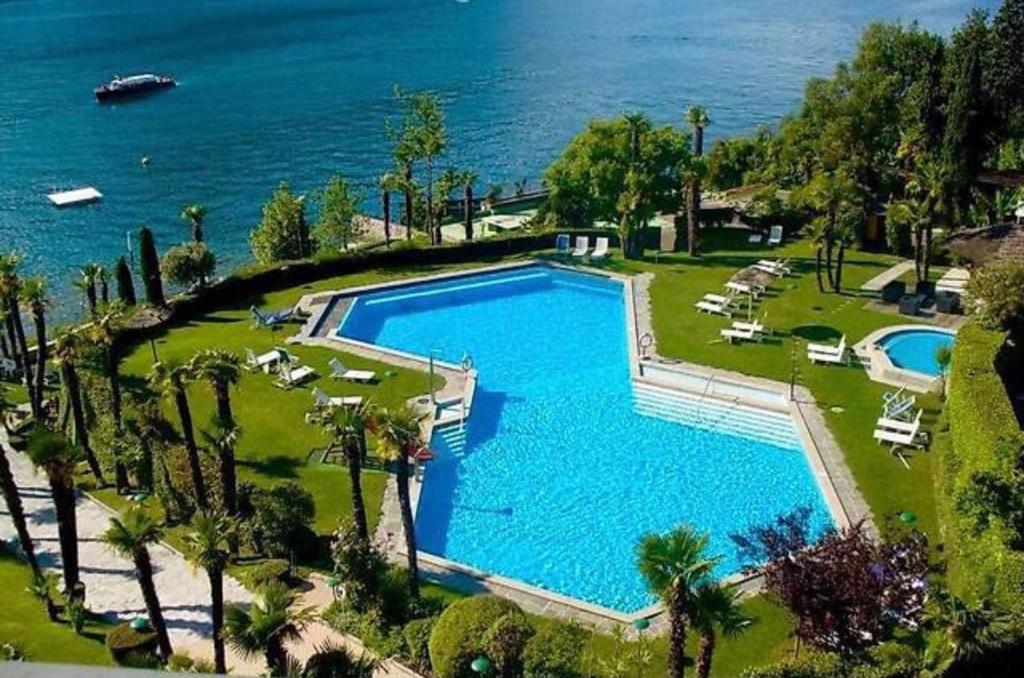 einen Blick über einen großen Pool neben dem Meer in der Unterkunft Holiday On The Lake Lugano 6 in Bissone