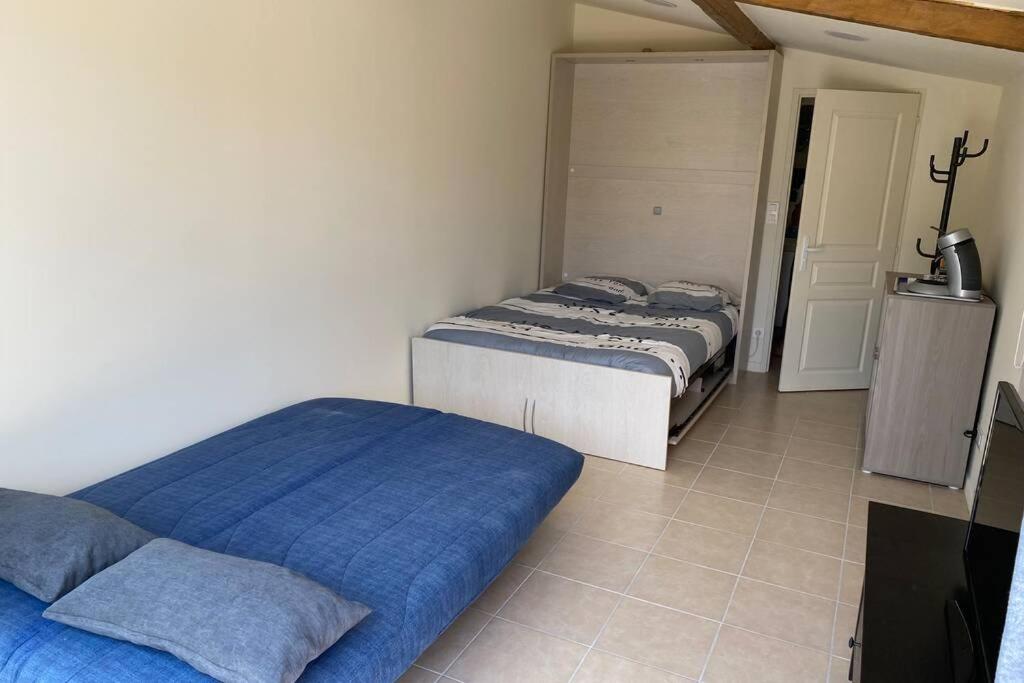a bedroom with two beds and a tv in it at Loft 21 m² pouvant accueillir 4 personnes in Monteux