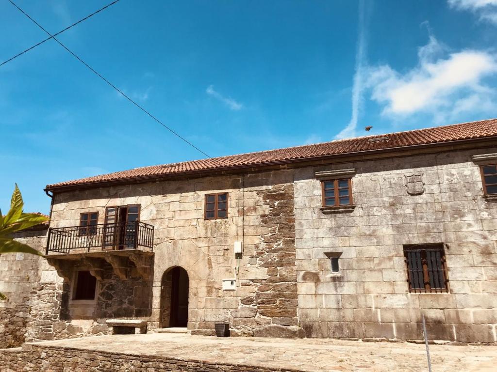 un antiguo edificio de piedra con balcón. en PAZO DE CÍCERE, en Cícere