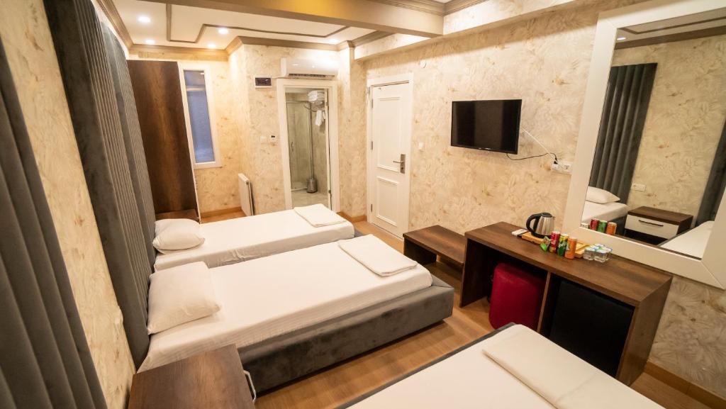 ein Hotelzimmer mit 2 Betten und einem TV in der Unterkunft DYMAR HOTEL in Istanbul