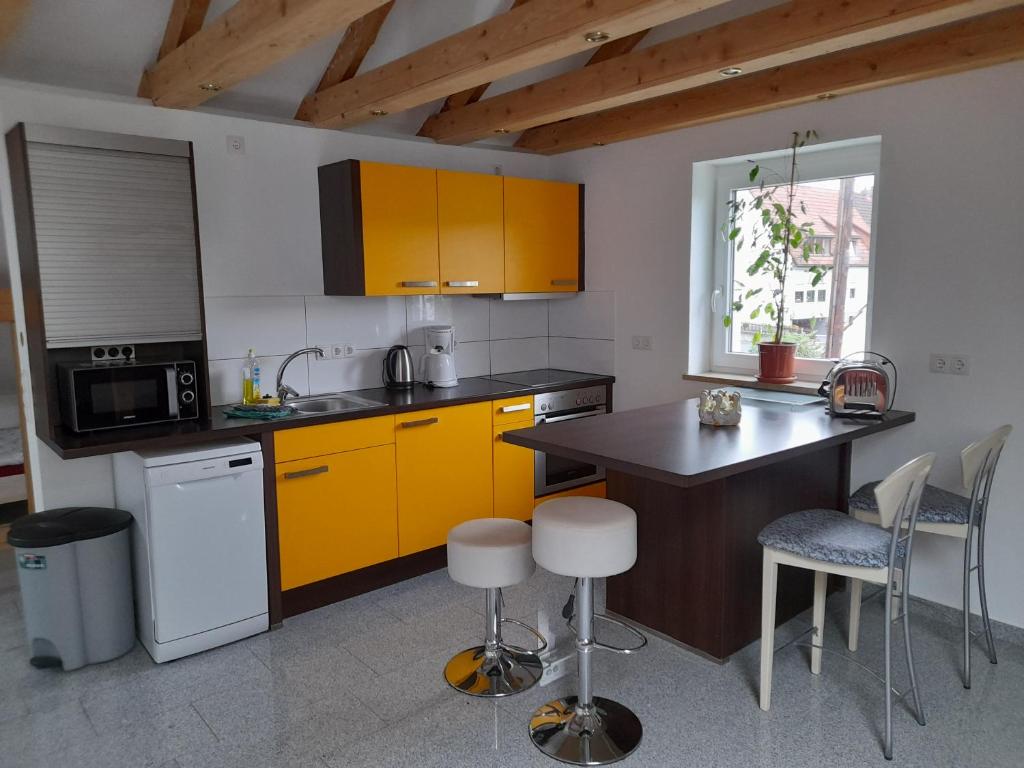 a kitchen with yellow cabinets and a table and chairs at Haus Lehenthaler in Stadtsteinach