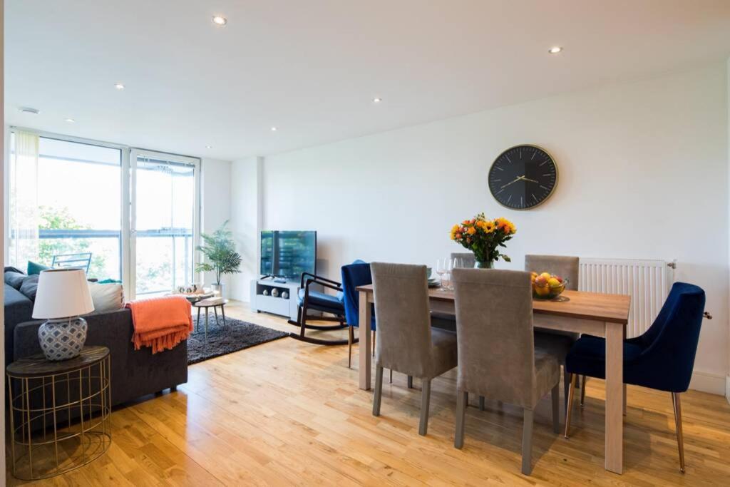 ein Esszimmer und ein Wohnzimmer mit einem Tisch und Stühlen in der Unterkunft Wild Roses Serviced Apartments - Greenwich in London