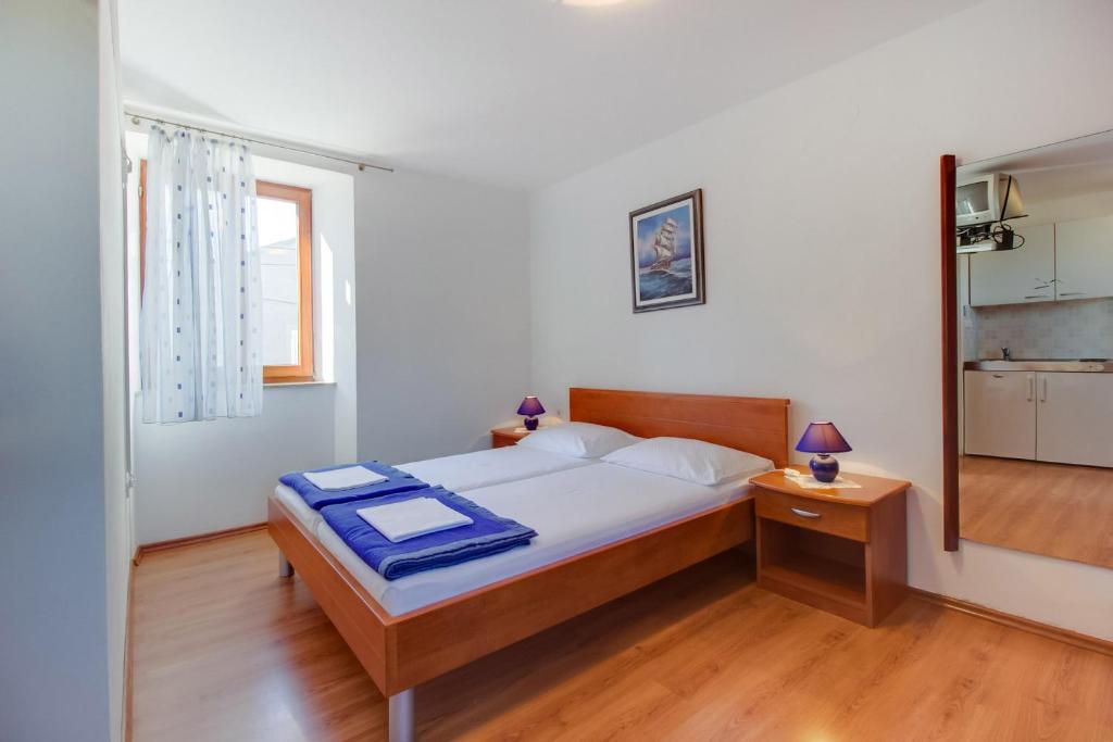 a bedroom with a bed and a table and a mirror at Apartments Rosa in Mali Lošinj