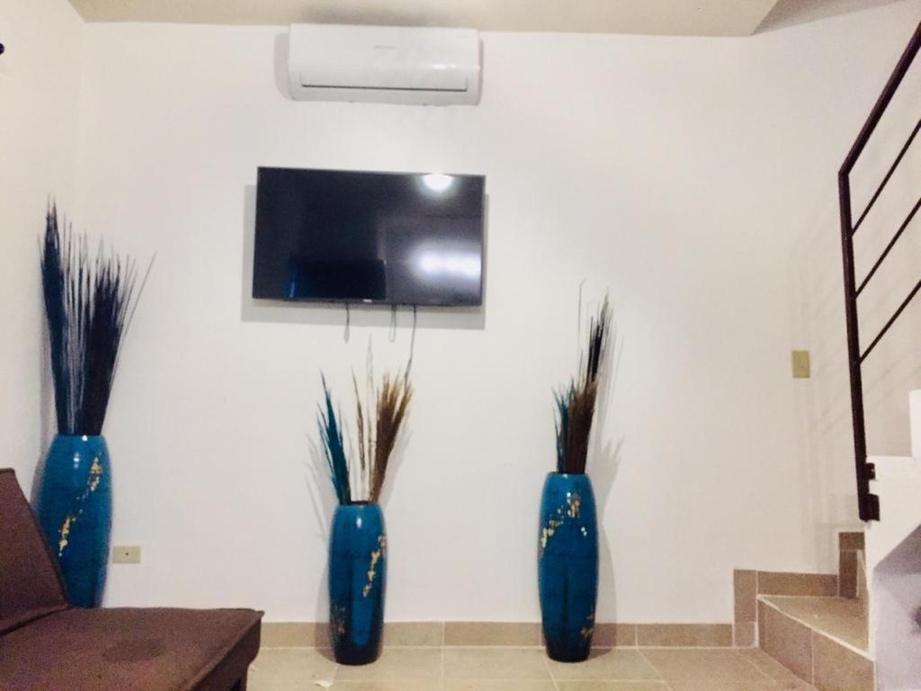 three blue vases sitting on a wall with a tv at Tu casa con pérgola en La Paz BCS in La Paz