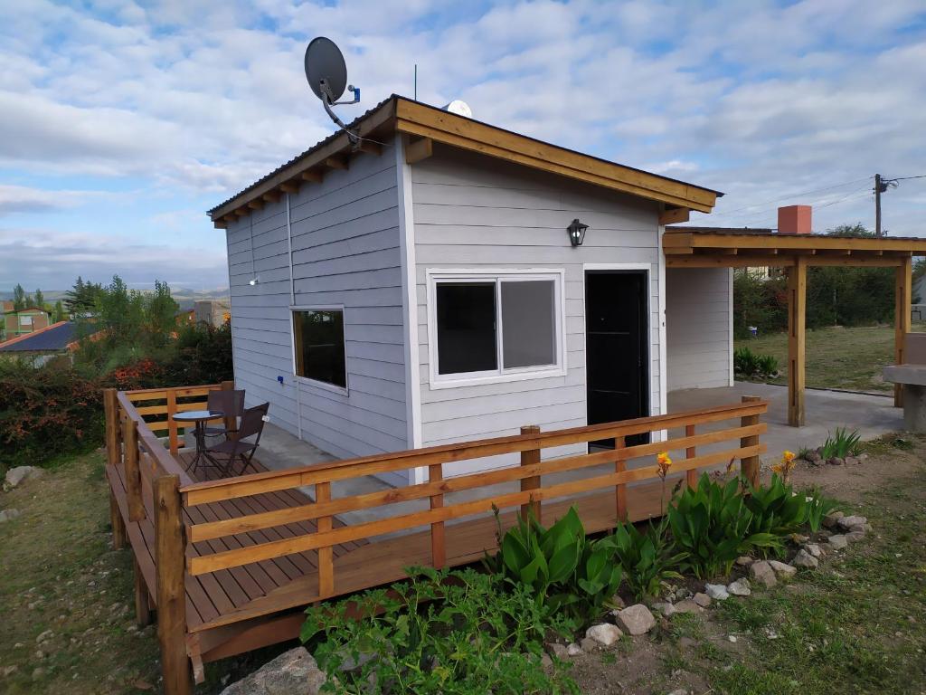 ein kleines Haus mit einer Veranda und einer Terrasse in der Unterkunft Palotes Sierras Cabañas in Villa Giardino