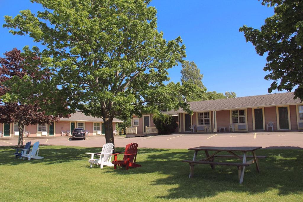 a picnic table and chairs in front of a building at Silverwood Motel in Cavendish