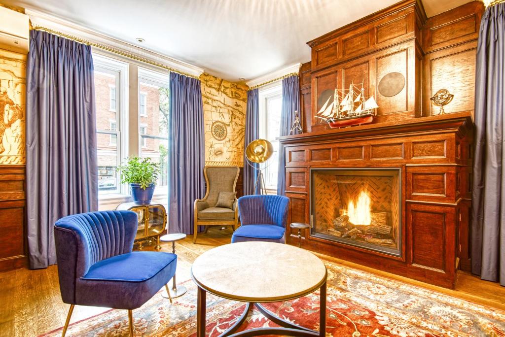 The Hudson Whaler في هدسون: غرفة معيشة بها موقد وكراسي زرقاء