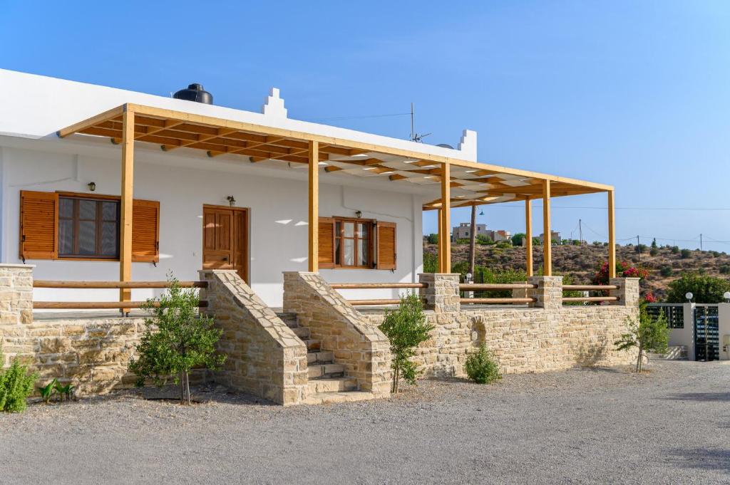 a white house with a stone wall at Villas Alexandros in Kalamaki