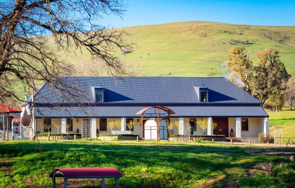 a farm house with a hill in the background at Brigham House in Tooma