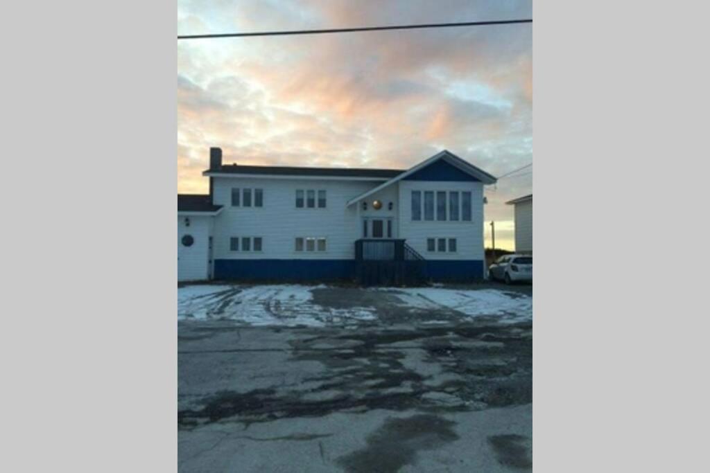 una gran casa blanca con un cielo en el fondo en Ocean Front House in Cook's Harbour Newfoundland, en Raleigh