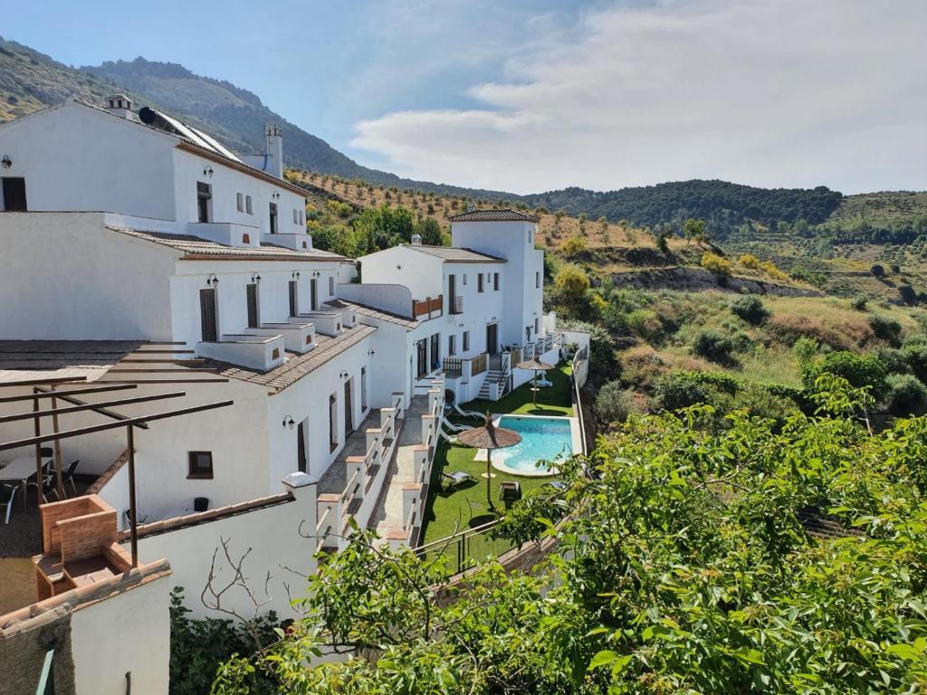 a row of white buildings with a swimming pool at La Luna del sur B&B in Granada