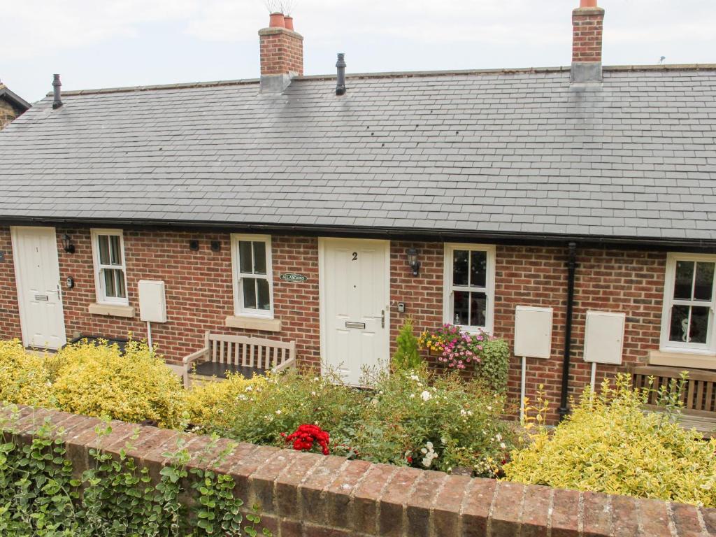 a red brick house with a gray roof at All Aboard in Whitby