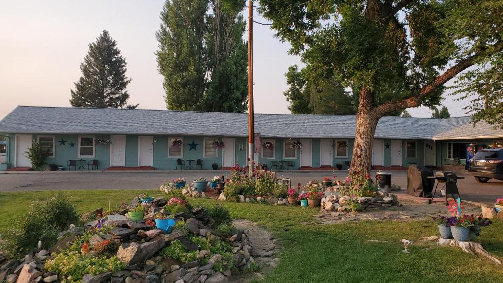 a building with a bunch of flowers in a yard at Sage Motel in Greybull