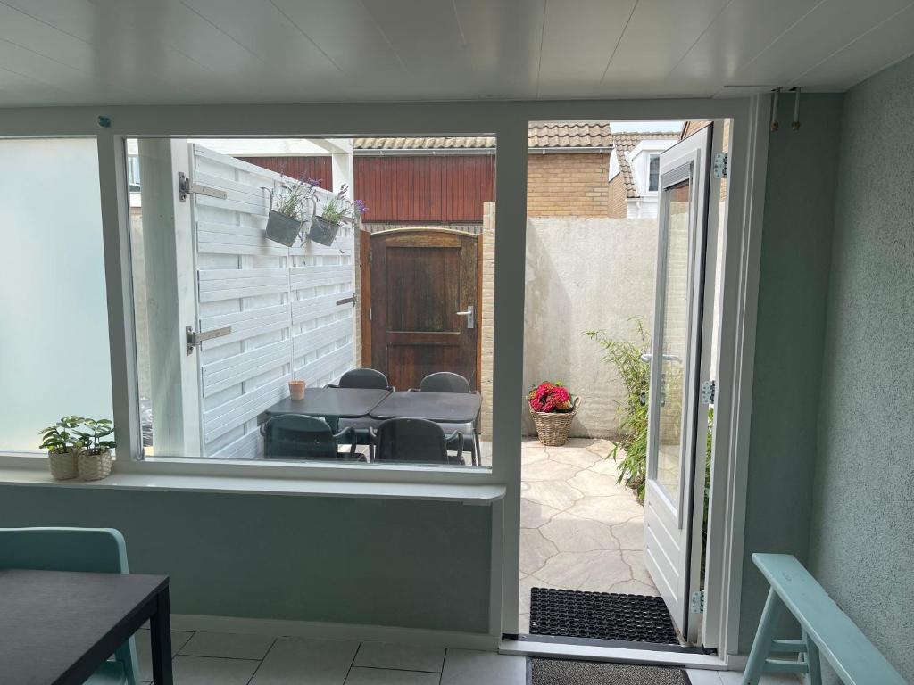 an open door to a patio with a table and chairs at Guesthouse West in Noordwijk