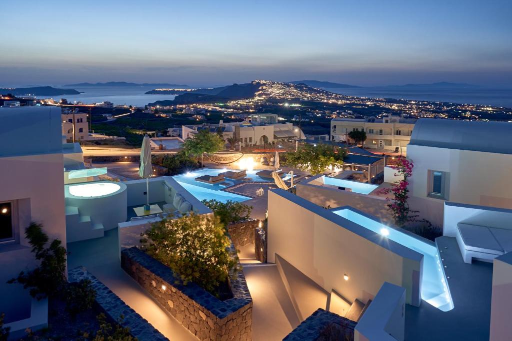 uitzicht op een stad in de nacht met gebouwen bij Nova Luxury Suites in Pirgos