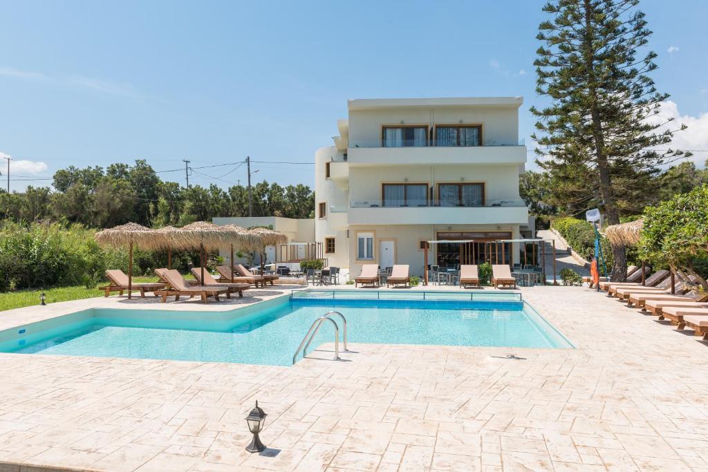 a villa with a swimming pool in front of a house at Musela Studios in Episkopí- Rethimno